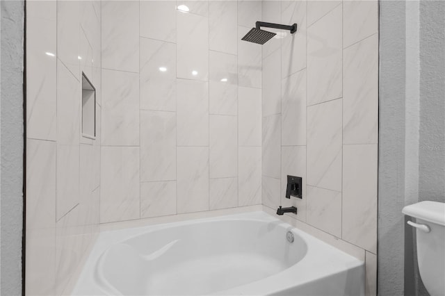 bathroom featuring toilet and tiled shower / bath combo