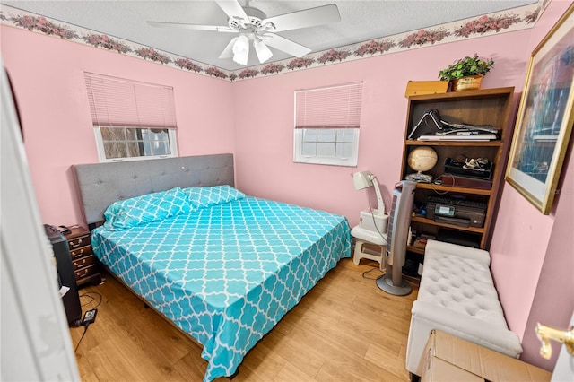 bedroom featuring wood-type flooring, a textured ceiling, and ceiling fan