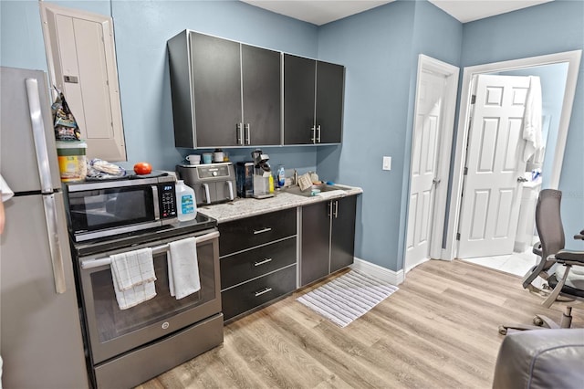 kitchen featuring appliances with stainless steel finishes and light hardwood / wood-style flooring