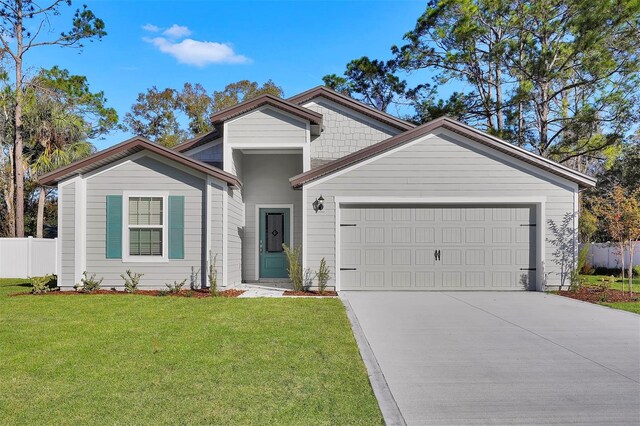 48 Prattwood Ln, Palm Coast, FL 32164 - view of front of home featuring an attached garage, concrete driveway, fence, and a front lawn