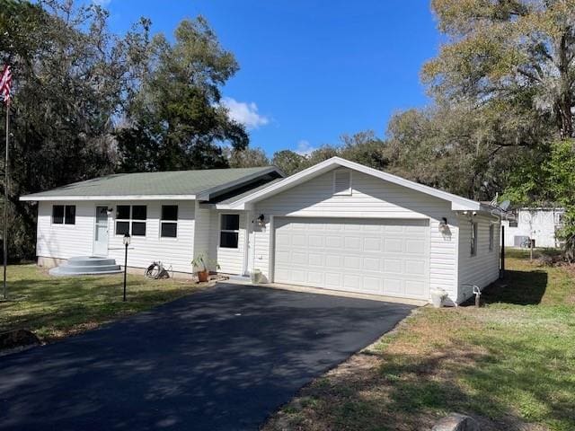 ranch-style home featuring a front yard, an attached garage, and aphalt driveway