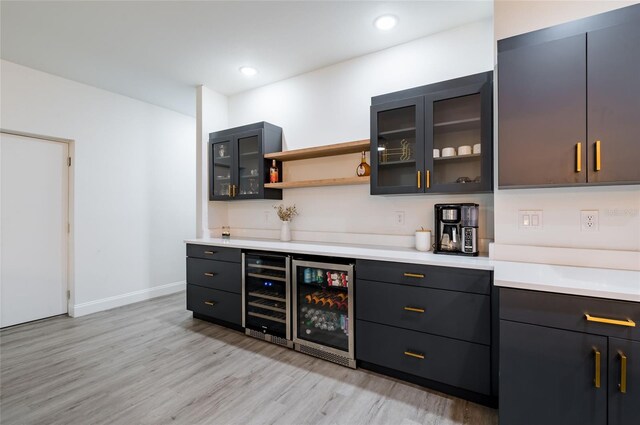 bar with beverage cooler and light hardwood / wood-style floors