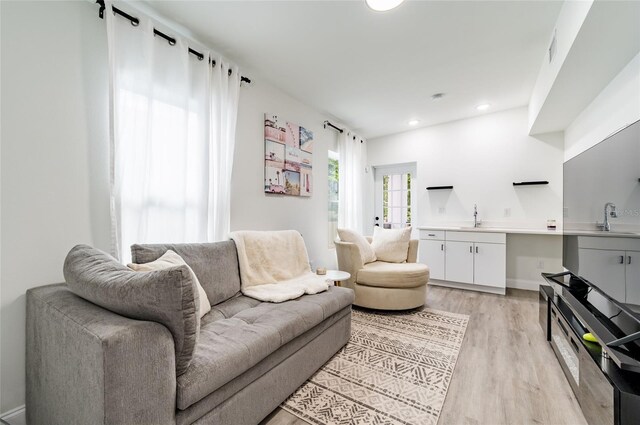 living room with sink and light wood-type flooring