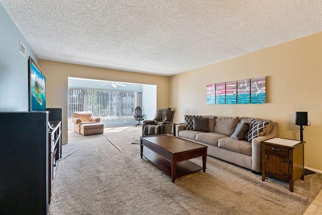 living room with carpet flooring, a textured ceiling, and ceiling fan