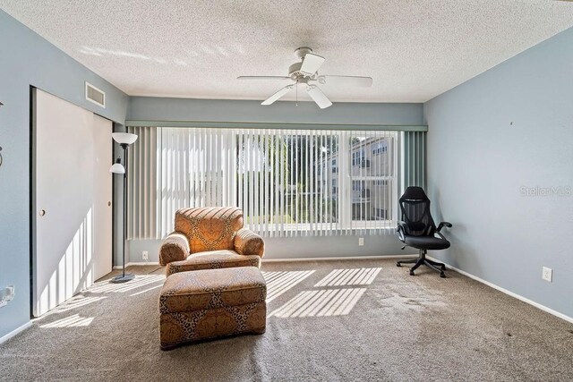 interior space featuring carpet floors, a textured ceiling, and ceiling fan