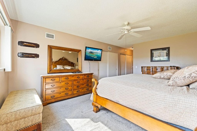 carpeted bedroom with a textured ceiling and ceiling fan