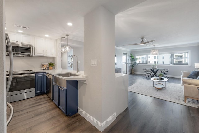 kitchen with sink, stainless steel appliances, white cabinets, blue cabinets, and kitchen peninsula