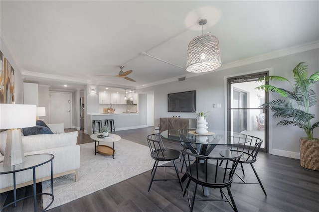 dining space featuring dark wood-type flooring, ornamental molding, and ceiling fan