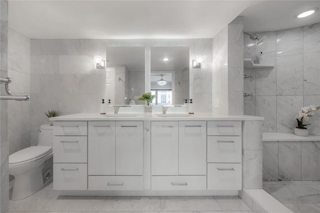 bathroom featuring vanity, tiled shower, tile walls, and toilet