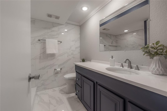 bathroom featuring crown molding, vanity, toilet, and tile walls