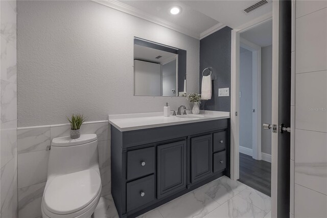 bathroom with crown molding, vanity, and toilet