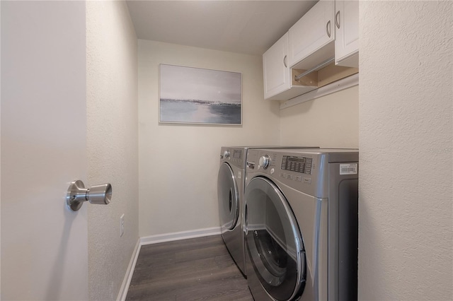 laundry room featuring cabinets, washing machine and dryer, and dark hardwood / wood-style flooring