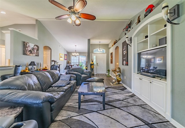 living area with wood finished floors, baseboards, lofted ceiling, arched walkways, and ceiling fan with notable chandelier