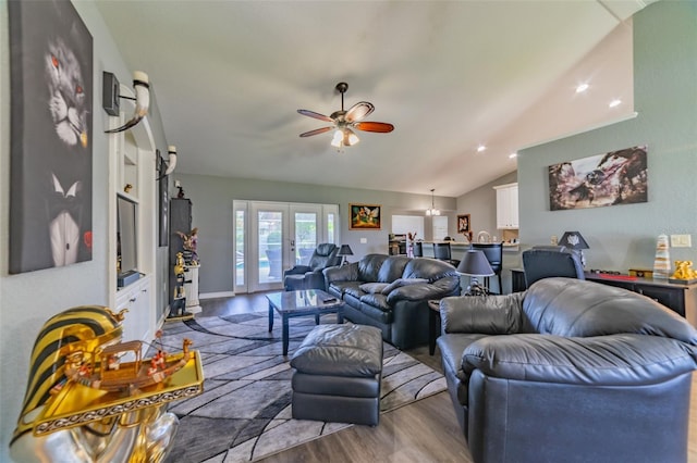 living room with baseboards, ceiling fan, vaulted ceiling, french doors, and wood finished floors