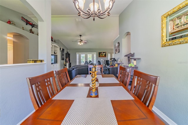 dining room with baseboards, arched walkways, lofted ceiling, and ceiling fan with notable chandelier