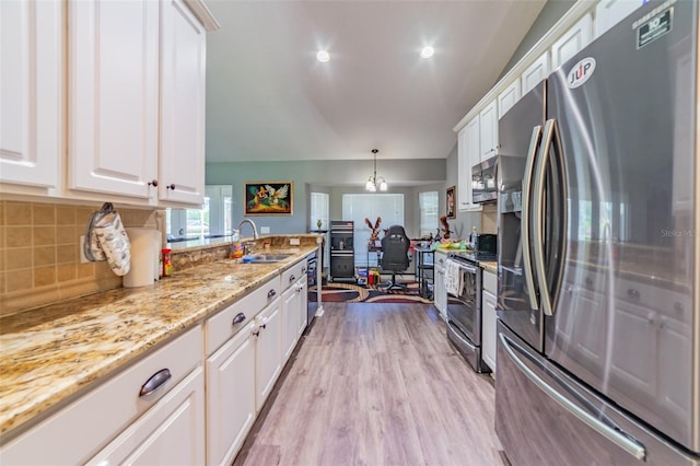 kitchen featuring white cabinets, stainless steel appliances, light wood-type flooring, and a sink