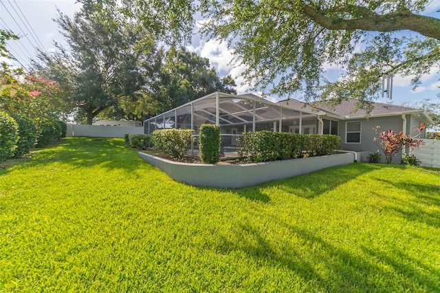 view of yard featuring a lanai and fence