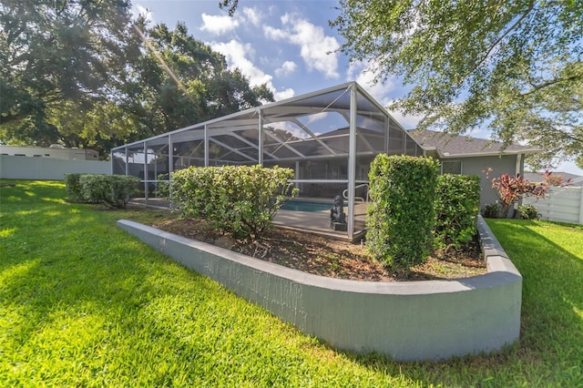 back of property featuring a lanai, a lawn, and fence