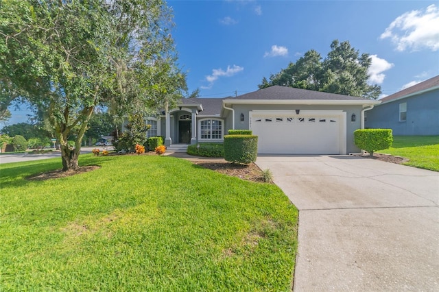 ranch-style home featuring stucco siding, an attached garage, concrete driveway, and a front lawn