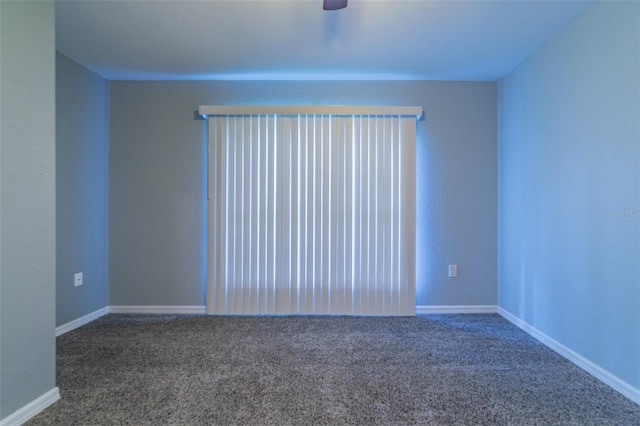 spare room featuring carpet flooring, a ceiling fan, and baseboards