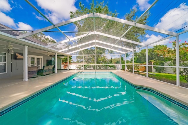 pool featuring a patio area, glass enclosure, french doors, and a ceiling fan