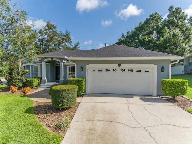 ranch-style home with stucco siding, driveway, a shingled roof, and a garage