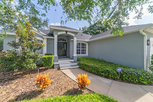 entrance to property with stucco siding and an attached garage