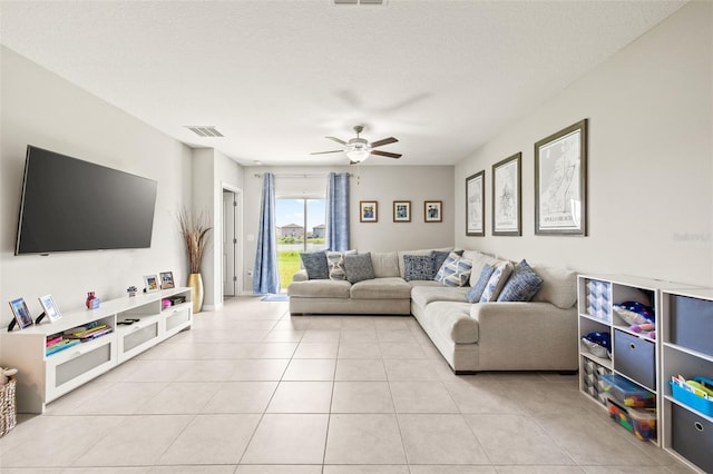 tiled living room featuring a textured ceiling and ceiling fan