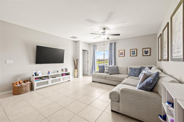 living room with light tile patterned flooring, a textured ceiling, and ceiling fan