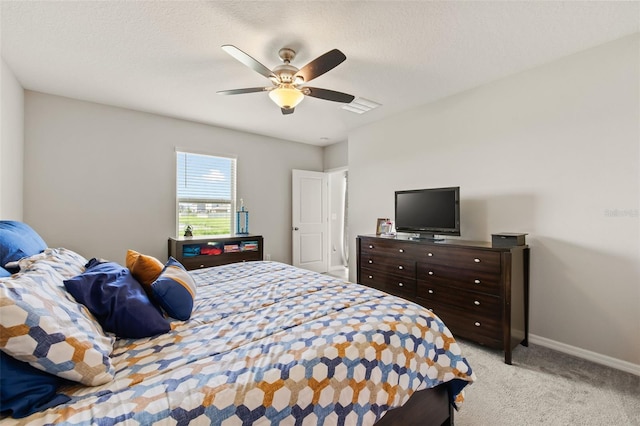 bedroom featuring light colored carpet, a textured ceiling, and ceiling fan