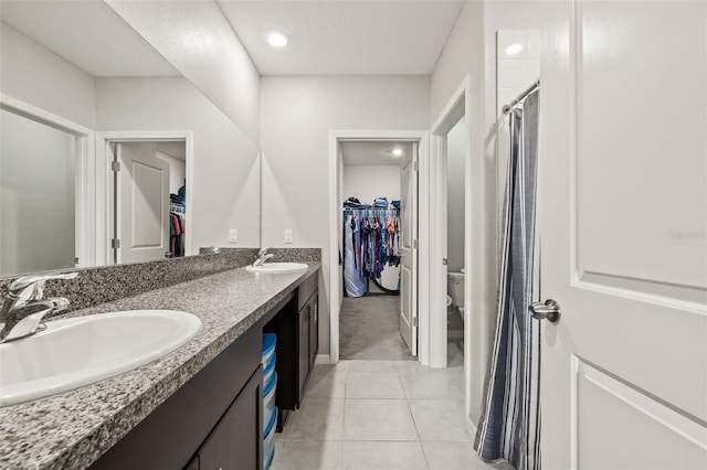 bathroom with tile patterned flooring, dual vanity, and toilet