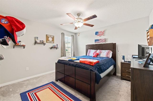 bedroom featuring light colored carpet, a textured ceiling, and ceiling fan