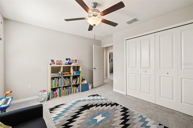 bedroom featuring light colored carpet, a closet, and ceiling fan