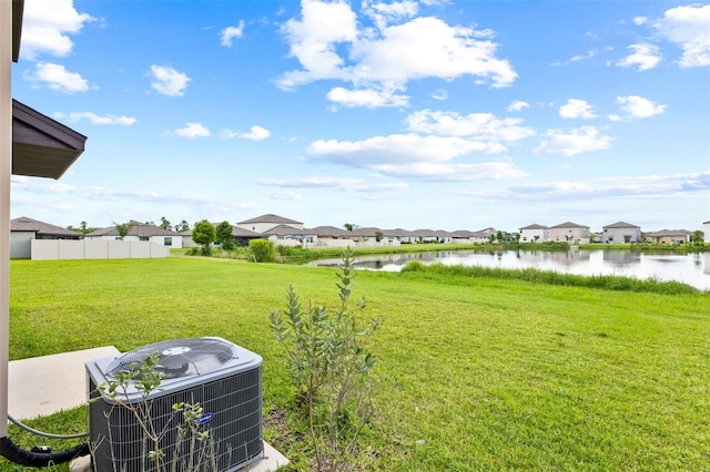 view of yard featuring a water view and central AC unit