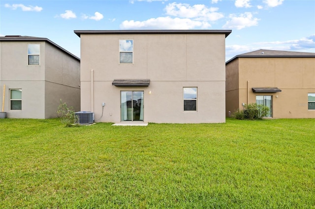 rear view of property with a yard and central AC unit