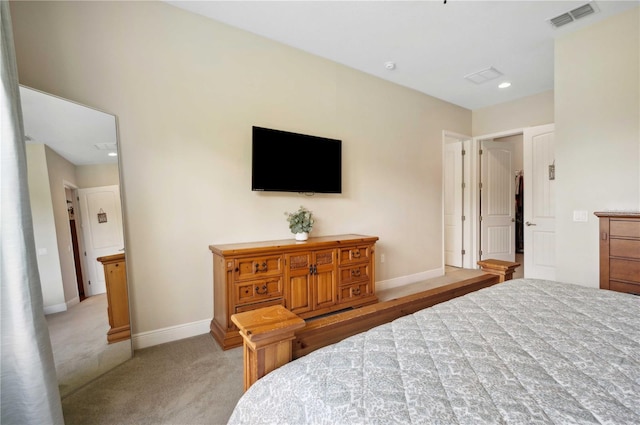 bedroom with light carpet and ensuite bathroom