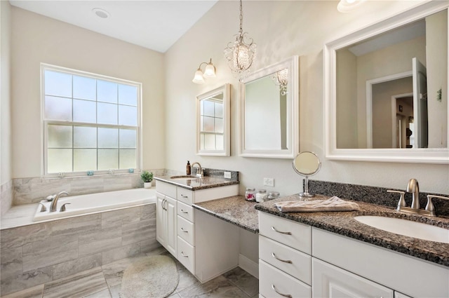 full bathroom with a chandelier, a garden tub, marble finish floor, and vanity