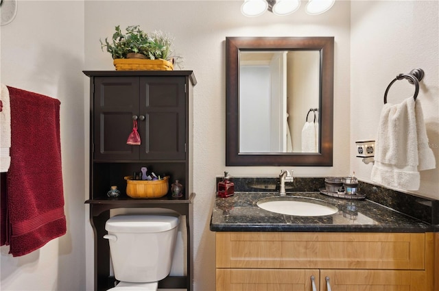 half bathroom with toilet and vanity