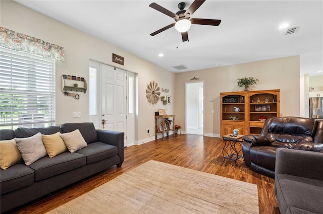 living room with dark hardwood / wood-style flooring and ceiling fan