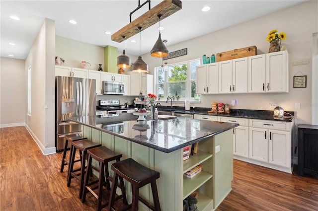 kitchen with stainless steel appliances, dark hardwood / wood-style floors, white cabinets, and a center island