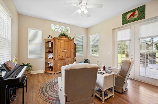 living area with hardwood / wood-style floors, ceiling fan, and plenty of natural light