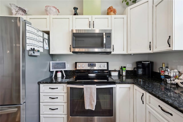 kitchen with dark stone countertops, appliances with stainless steel finishes, and white cabinets