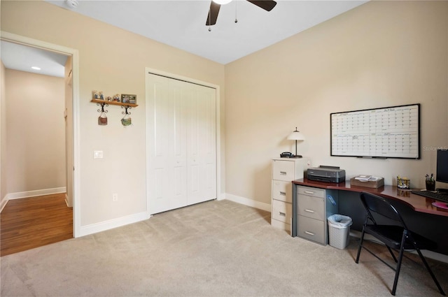 carpeted home office featuring ceiling fan