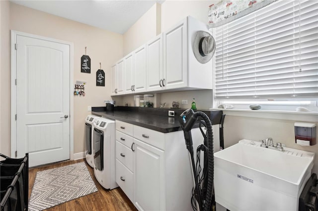 washroom with cabinets, dark hardwood / wood-style floors, sink, and washing machine and clothes dryer