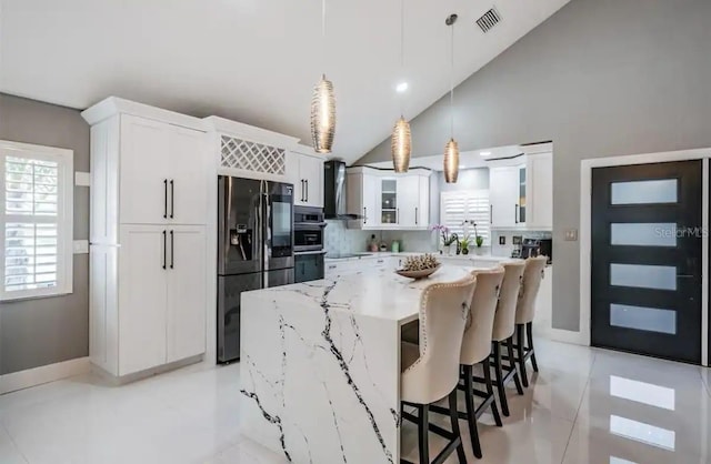 kitchen featuring appliances with stainless steel finishes, hanging light fixtures, light tile patterned floors, and white cabinetry