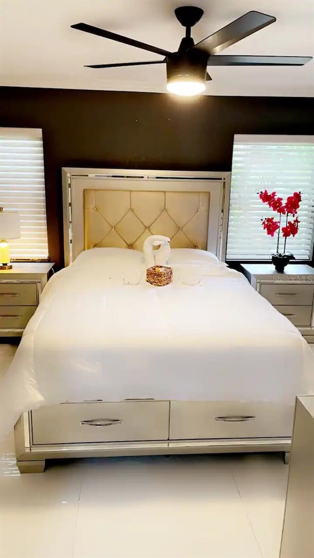 tiled bedroom featuring ceiling fan