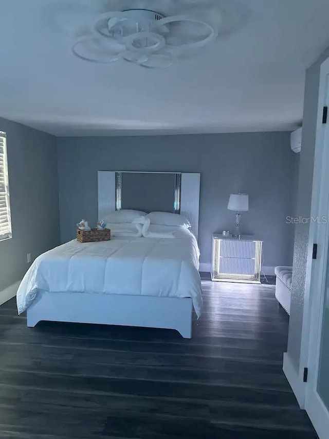 bedroom featuring dark wood-type flooring and a wall mounted air conditioner