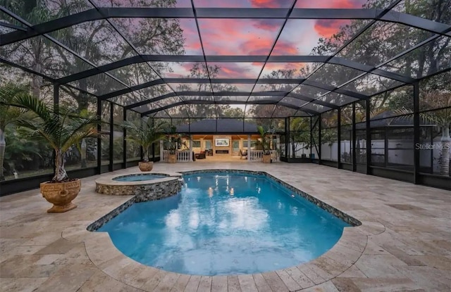 pool at dusk featuring a patio, an in ground hot tub, and glass enclosure