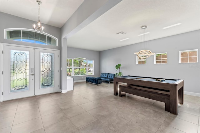 foyer entrance featuring french doors, a chandelier, light tile patterned flooring, and billiards