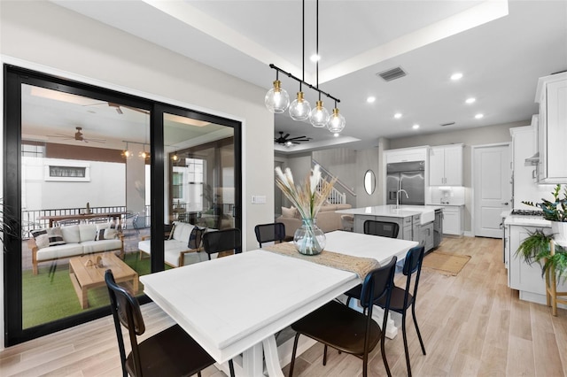 dining space with a healthy amount of sunlight, light hardwood / wood-style floors, and ceiling fan